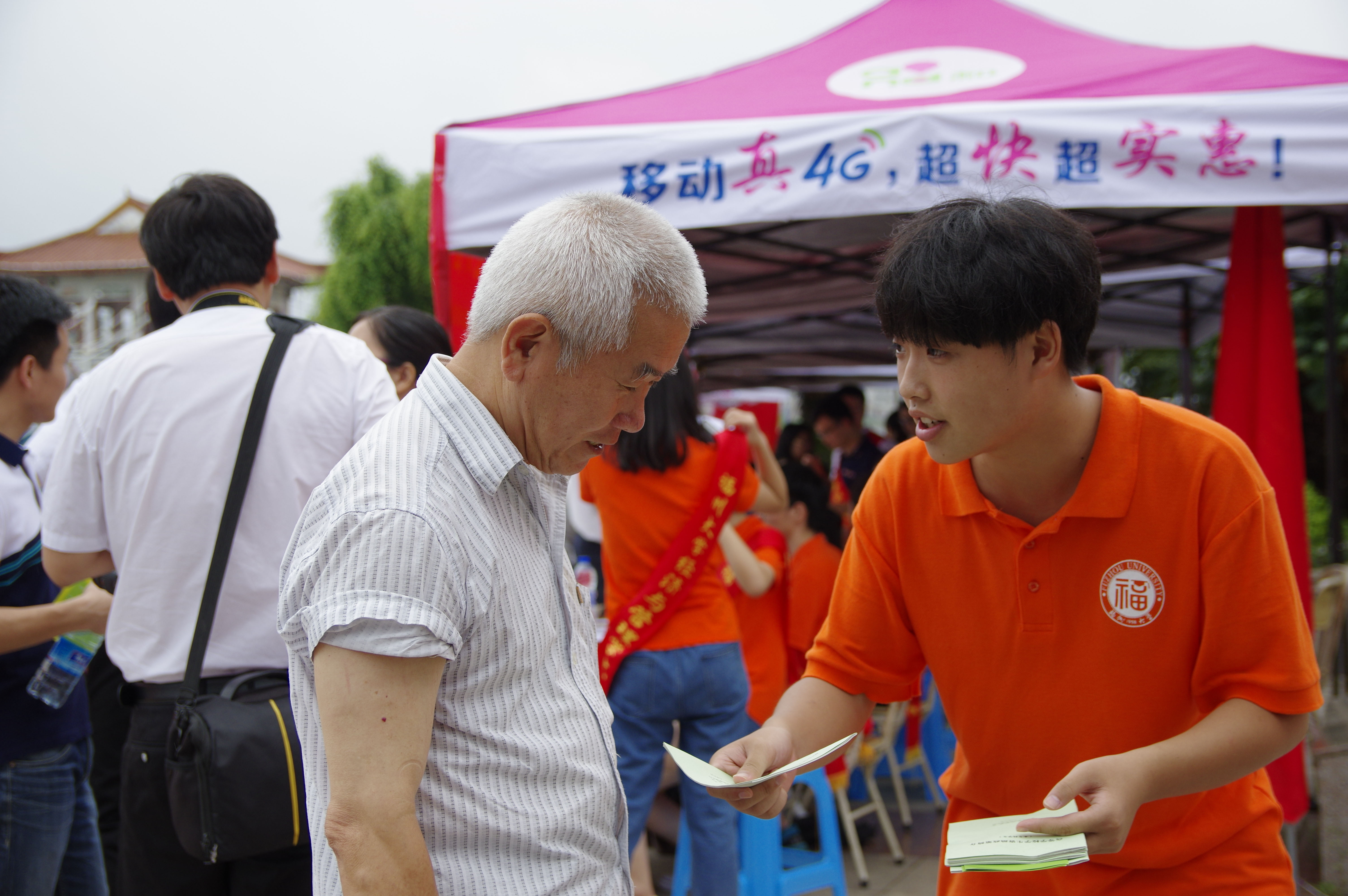 参与社会实践的同学向群众派发宣传单  郑昊焜摄影